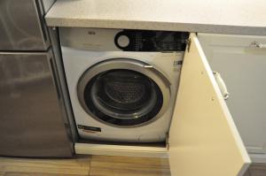 uma máquina de lavar roupa debaixo de um balcão numa cozinha em House near to Schönbrunn - Free Parking - 24-7 Check in - 8 Person em Viena