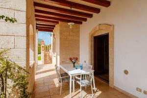 een witte tafel en stoelen op een patio bij HelloApulia Family Villa with Pool, Lush Garden & BBQ - Near the Beache in Savelletri di Fasano