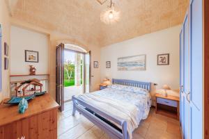een slaapkamer met een bed en een raam bij HelloApulia Family Villa with Pool, Lush Garden & BBQ - Near the Beache in Savelletri di Fasano