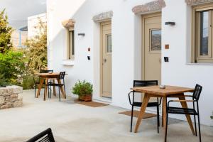 eine Terrasse mit Tischen und Stühlen auf einem Haus in der Unterkunft Soil Amorgos in Katápola