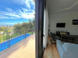 sala de estar con balcón con vistas a la piscina en Villa de lujo con vistas al mar y piscina privada, en Santa Susanna