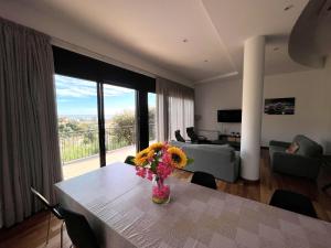 una sala de estar con una mesa con un jarrón de flores. en Villa de lujo con vistas al mar y piscina privada, en Santa Susanna