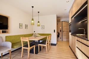 cocina y comedor con mesa y sillas en Siplinger Suites - Ferienwohnungen - Sauna und Fitness, en Balderschwang
