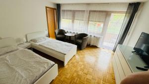1 dormitorio con 2 camas, mesa y ventana en G.O.D. Ferienwohnung, en Bad Mergentheim