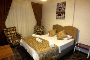 um quarto de hotel com uma cama e uma cadeira em LYSUİT em Kırac