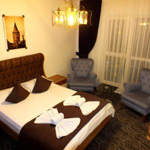 um quarto de hotel com uma cama e duas cadeiras em LYSUİT em Kırac