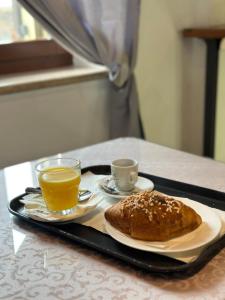 una bandeja con un plato de pan y una taza de zumo de naranja en Residenza Villa Bella, en Mozzecane