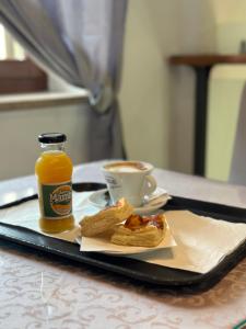bandeja con una botella de zumo de naranja y una taza de café en Residenza Villa Bella, en Mozzecane