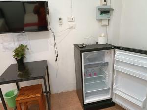 um frigorífico com a porta aberta ao lado de uma mesa em โรงแรมแอมไอม่อน - Am Amoonds Hotel em Khlung