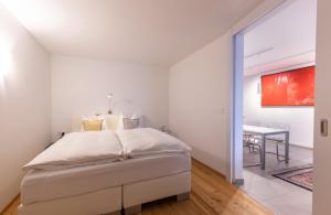 a white bedroom with a bed and a dining room at Lakefront Suite 148 by we rent in Zell am See