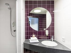 a bathroom with a sink and a mirror at B&B Hotel Lüneburg in Lüneburg
