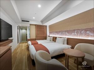 那覇市にあるダイワロイネットホテル那覇おもろまちＰＲＥＭＩＥＲのベッド1台、薄型テレビが備わるホテルルームです。