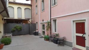 a courtyard between two buildings with chairs and plants at Hotel Della Volta in Brescia