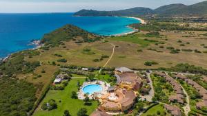 an aerial view of a house on a hill next to the ocean at Sant'Elmo Beach Hotel in Castiadas