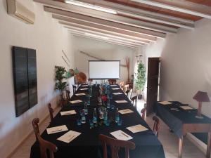 a long table in a room with chairs and a screen at Boutique Hotel Sa Galera in Caʼs Concos
