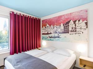 Schlafzimmer mit einem Bett mit roten Vorhängen in der Unterkunft B&B Hotel Lüneburg in Lüneburg