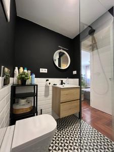 y baño con aseo, lavabo y espejo. en Precioso apartamento céntrico en vigo, en Vigo
