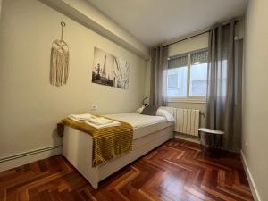 1 dormitorio pequeño con 1 cama y suelo de madera en Precioso apartamento céntrico en vigo, en Vigo