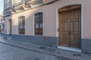 a building with a large wooden door on a street at ISG Apartments Apartamento cerca de la Catedral in Seville