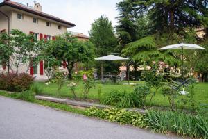 un jardín con 2 sombrillas en un patio en B&B PIEDICASTELLO en Trento