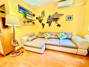 a living room with a couch and a world map on the wall at Benett apartman in Budapest
