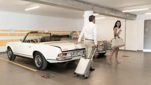 バルドリーノにあるSan Colombano Suitesの白い車の横に立つ男女