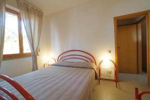 a bedroom with a bed in a room with a window at Appartamenti Campeggio del Forte in Marina di Bibbona +28 photos