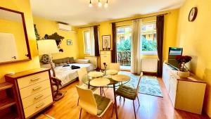 a living room with a table and a bedroom at Benett apartman in Budapest