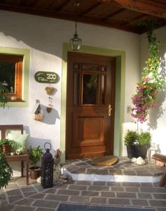 einer Haustür eines Hauses mit Topfpflanzen in der Unterkunft Appartements Huber in Altenmarkt im Pongau