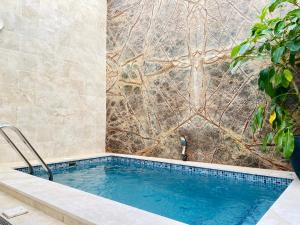 a swimming pool in a bathroom with a tile wall at Sliema 8 Bedroom House with Pool in Sliema