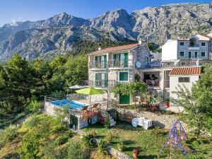 a house on a hill with mountains in the background at Holiday home Colla in Tučepi