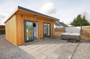 a small wooden building with a hot tub in it at Beth's Bothy in Gatehouse of Fleet