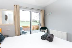 a bedroom with a bed and a large window at Beth's Bothy in Gatehouse of Fleet