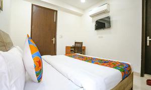 ein Schlafzimmer mit einem Bett und einem TV in der Unterkunft FabExpress Premium Room I in Neu-Delhi