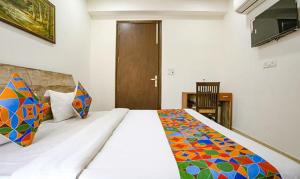 ein Schlafzimmer mit einem großen Bett mit einer bunten Decke in der Unterkunft FabExpress Premium Room I in Neu-Delhi