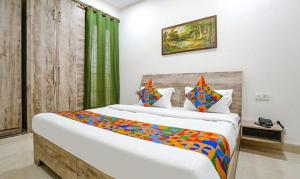 ein Schlafzimmer mit einem großen Bett mit einer bunten Decke in der Unterkunft FabExpress Premium Room I in Neu-Delhi