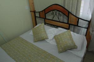 een bed met twee kussens erop bij Cherry home in Nairobi
