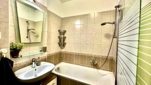 a bathroom with a sink and a tub and a mirror at Benett apartman in Budapest +28 photos