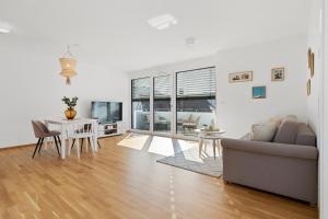 a living room with a couch and a table at ANYTIME - Riedlepark Apartments in Friedrichshafen