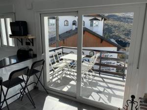 a room with a balcony with a table and chairs at APARTAMENTO PRECIOSO SOL Y SIERRA in Sierra Nevada