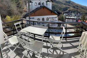 eine Gruppe Stühle und ein Tisch auf dem Balkon in der Unterkunft APARTAMENTO PRECIOSO SOL Y SIERRA in Sierra Nevada