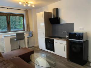a living room with a couch and a kitchen with a microwave at My Loft by Esen Hamburg Netflix, Parkplatz, Terasse in Hamburg