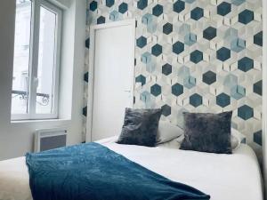 a bedroom with a bed with a geometric wall at LA MIDOUZE - Hyper Centre in Mont-de-Marsan