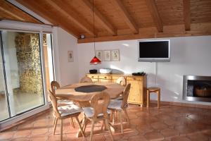 - une salle à manger avec une table, des chaises et une télévision dans l'établissement Tgamutsch (461 Tä), à Lenzerheide