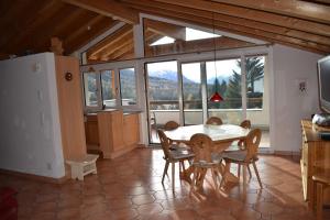 een eetkamer met een tafel, stoelen en ramen bij Tgamutsch (461 Tä) in Lenzerheide