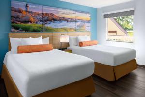 2 camas en una habitación con un cuadro en la pared en Days Inn by Wyndham Queensbury/Lake George en Queensbury