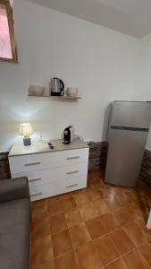 a kitchen with a refrigerator and a table with a lamp at STANZA CORSICA in Alghero