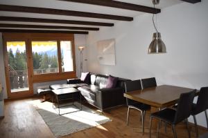 een woonkamer met een bank en een tafel bij Bella Val (272 Pe) in Lenzerheide