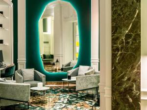 a lobby with chairs and a blue wall at Sofitel Roma Villa Borghese in Rome