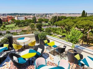 a balcony with tables and chairs and a view of the city at Sofitel Roma Villa Borghese in Rome